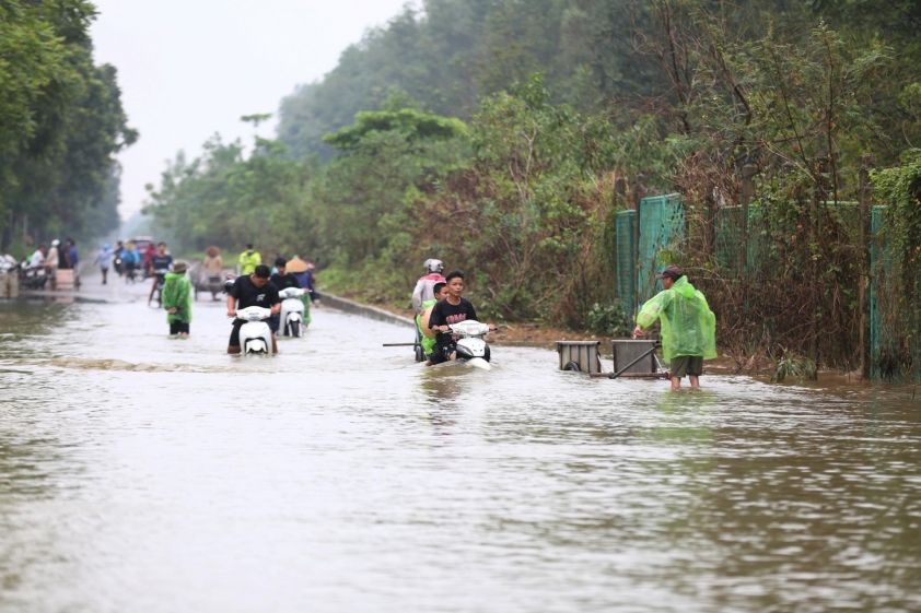Nghịch lý mưa tạnh nhưng vẫn ngập sâu, người dân qua Đại lộ Thăng Long chấp nhận thuê xe bò để