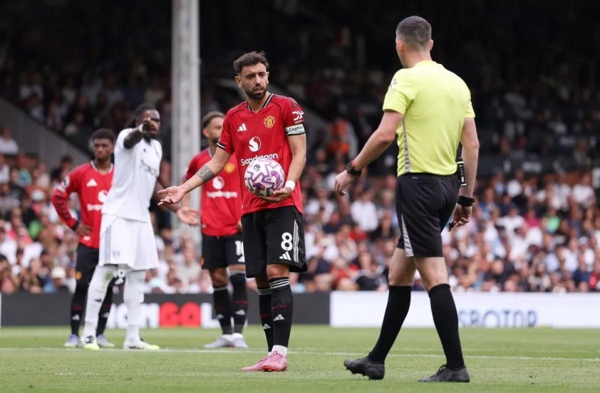 Bruno Fernandes không hài lòng với Chris Kavanagh sau khi trọng tài va vào anh (Ảnh: Catherine Ivill - AMA)
