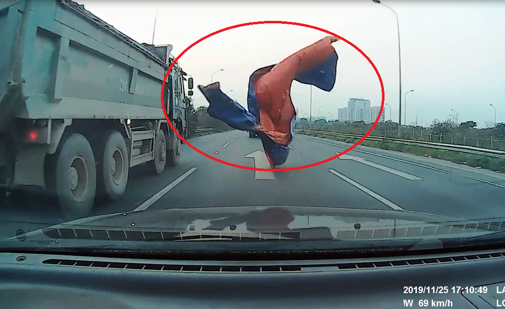 Xe tải đánh rơi bạt trùm kín đầu xe con, tài xế thót tim phanh gấp