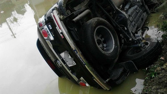 Chiếc Fortuner bị lật ngang xuống ao