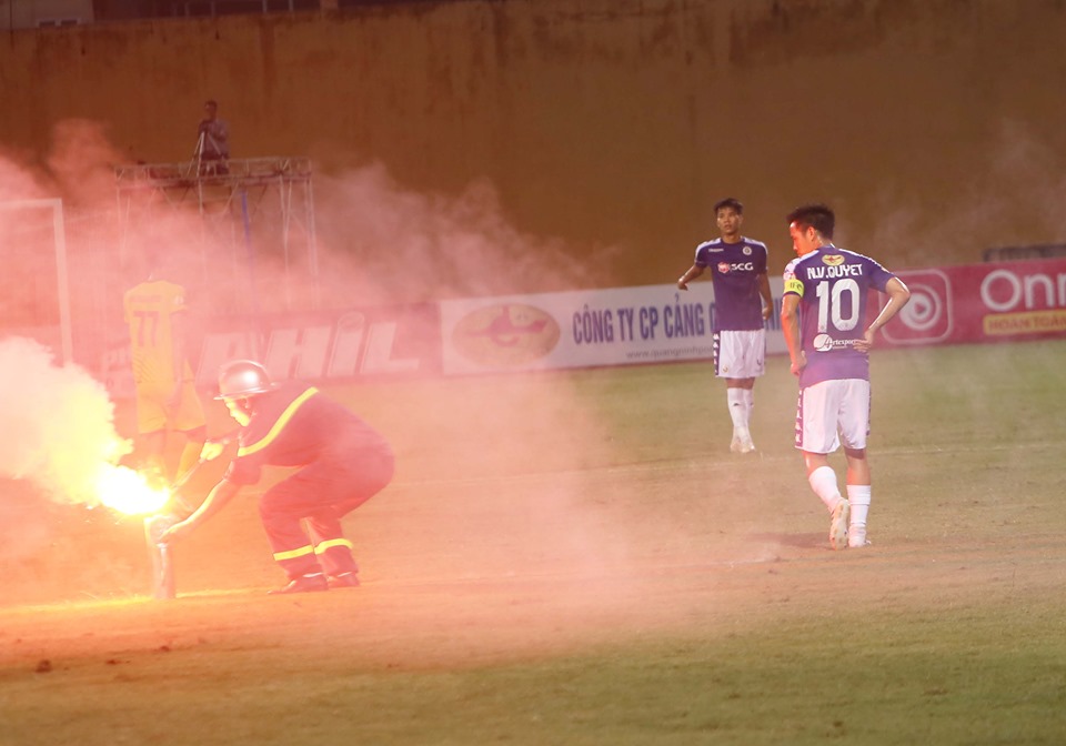 Văn Quyết đứng lặng người nhìn chiến sỹ cảnh sát dập quả pháo sáng (Ảnh: Văn Hải)